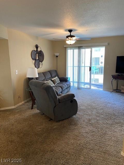 carpeted living area featuring ceiling fan, baseboards, and a textured ceiling