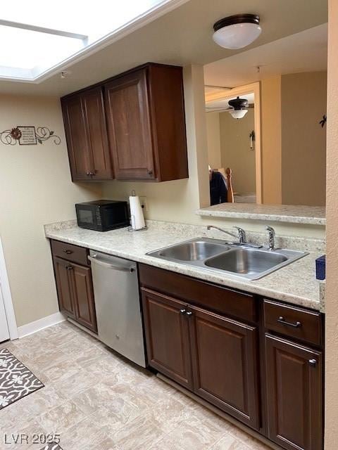 kitchen with a skylight, dark brown cabinetry, dishwasher, and sink