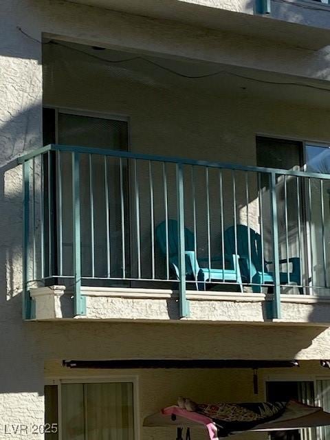 view of side of home with a balcony and stucco siding