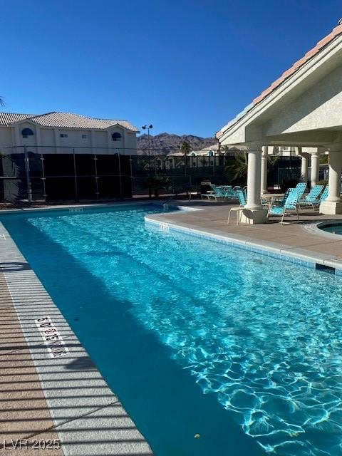 community pool with a patio and a mountain view