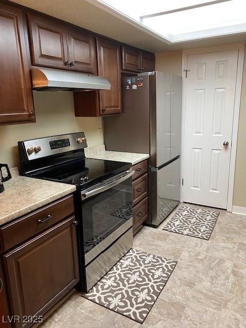 kitchen with under cabinet range hood, dark brown cabinets, appliances with stainless steel finishes, and light countertops