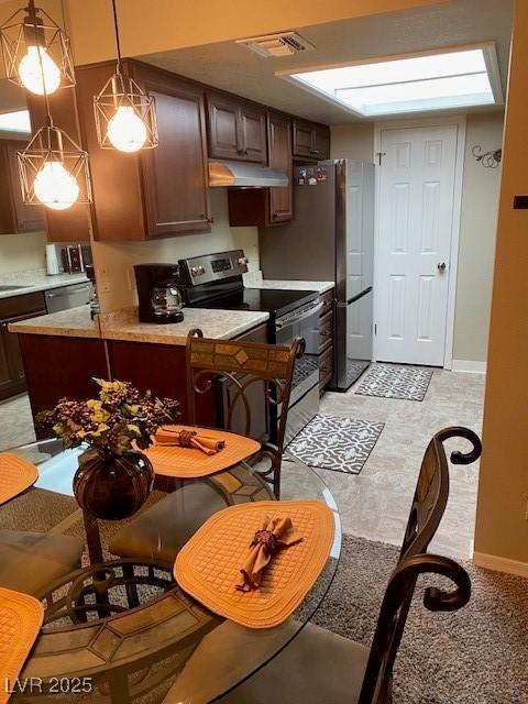 kitchen featuring sink, decorative light fixtures, dark brown cabinets, and appliances with stainless steel finishes