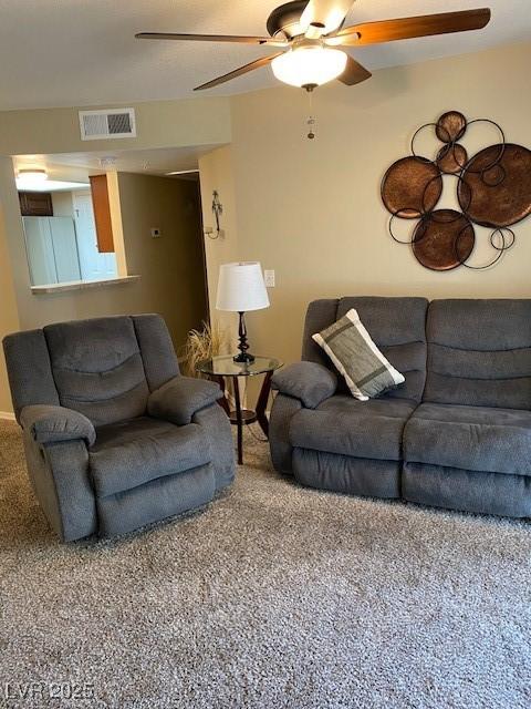 carpeted living room with ceiling fan