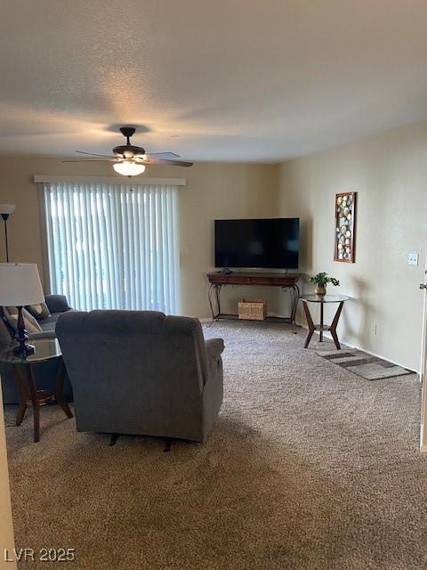 living area featuring a textured ceiling, ceiling fan, and carpet flooring