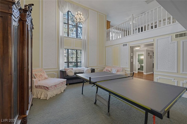 playroom featuring a high ceiling, an inviting chandelier, and plenty of natural light