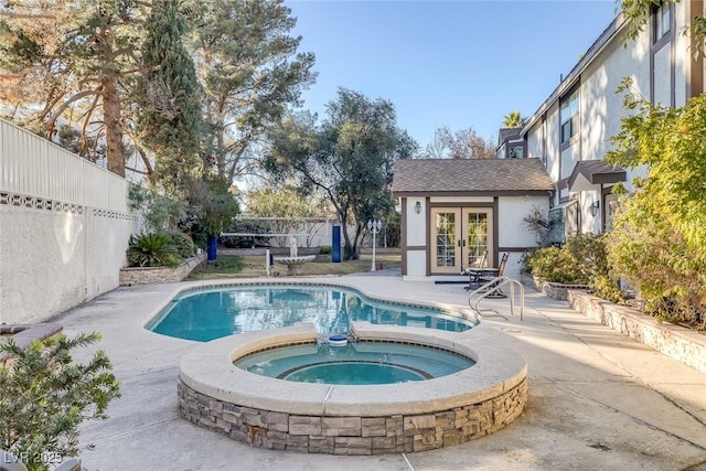 view of swimming pool featuring an outbuilding, an in ground hot tub, and a patio area