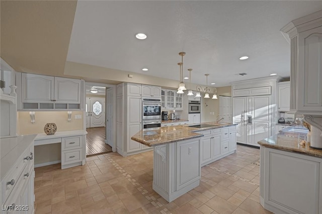 kitchen with paneled built in fridge, a center island, light stone countertops, pendant lighting, and white cabinetry