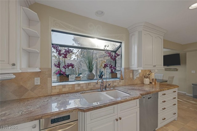 kitchen with sink, white cabinets, light stone counters, tasteful backsplash, and stainless steel dishwasher