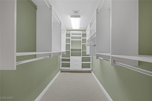 walk in closet featuring light colored carpet