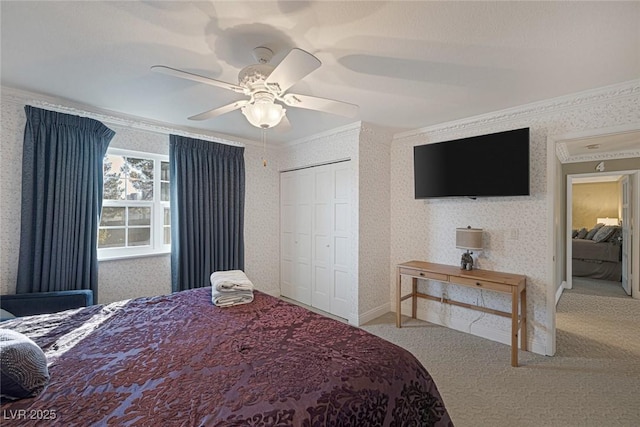 carpeted bedroom with ceiling fan, crown molding, and a closet