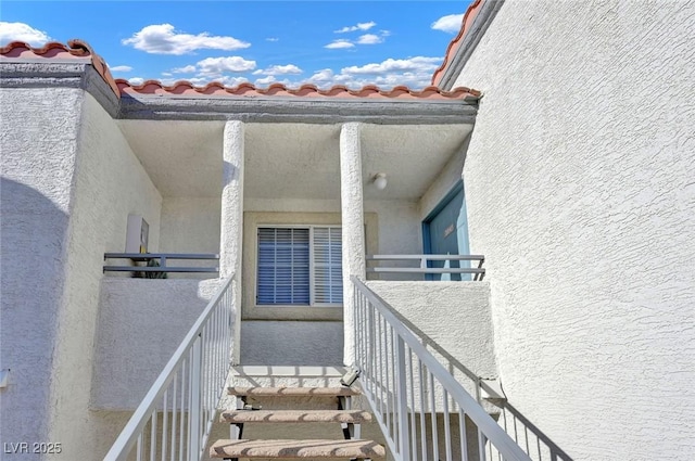 view of exterior entry with a balcony