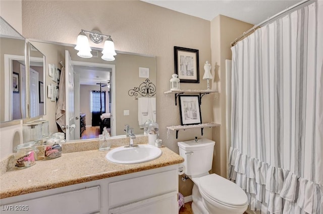 bathroom with toilet, a shower with shower curtain, and vanity