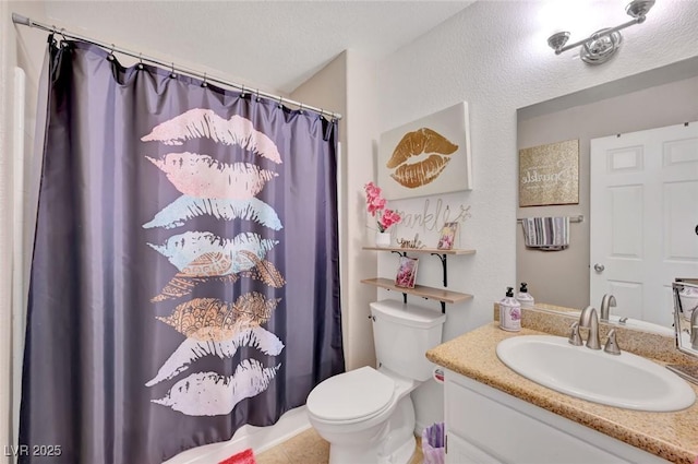 bathroom with a textured ceiling, vanity, and toilet