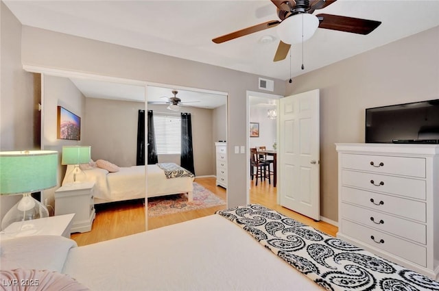 bedroom with ceiling fan, light wood-type flooring, and a closet