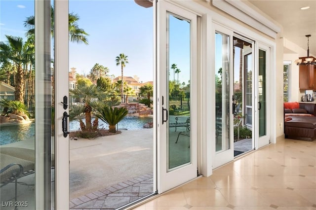 entryway featuring french doors, a water view, and light tile patterned floors