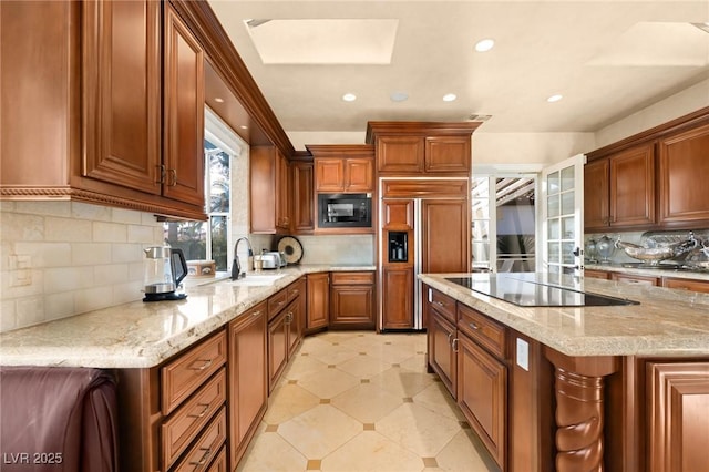 kitchen with tasteful backsplash, light stone countertops, sink, and black appliances