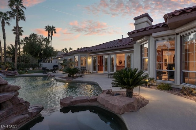 pool at dusk with a patio