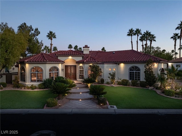 mediterranean / spanish-style home featuring a lawn