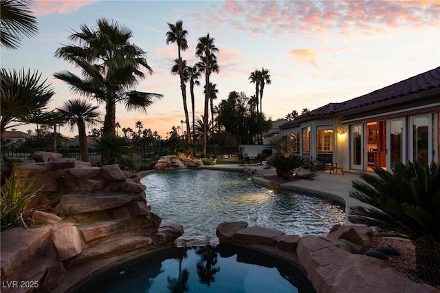 pool at dusk with a patio