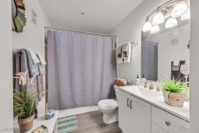 full bathroom with shower / tub combo with curtain, vanity, wood-type flooring, and toilet