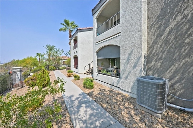 view of home's exterior featuring a balcony and central AC unit