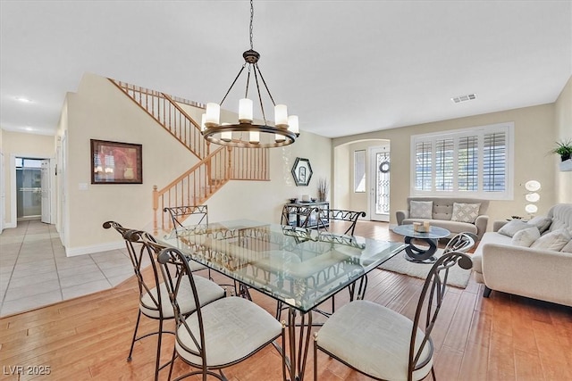 dining room featuring light wood-type flooring and a notable chandelier