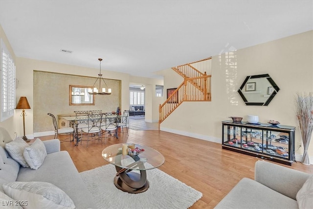 living room featuring hardwood / wood-style flooring and an inviting chandelier