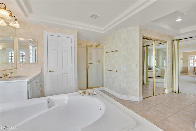 bathroom with vanity, a tray ceiling, tile patterned floors, and a tub