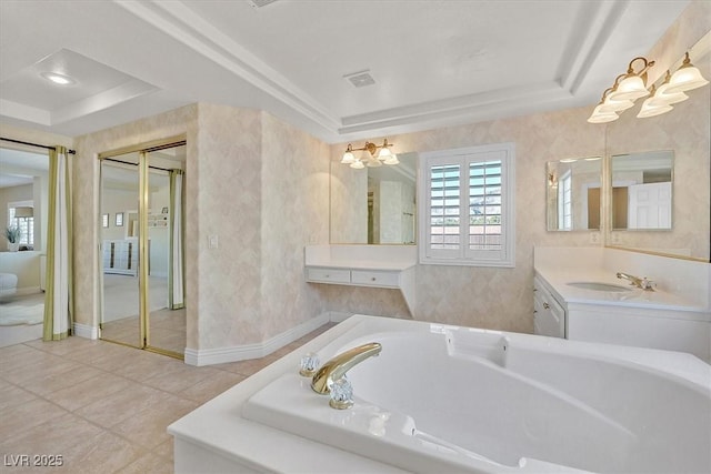 bathroom featuring a raised ceiling, tile patterned floors, a bathtub, and vanity