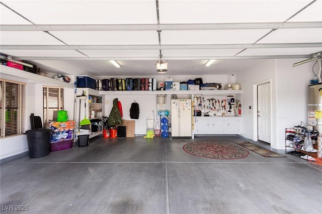 garage with a workshop area, white refrigerator, a garage door opener, and water heater