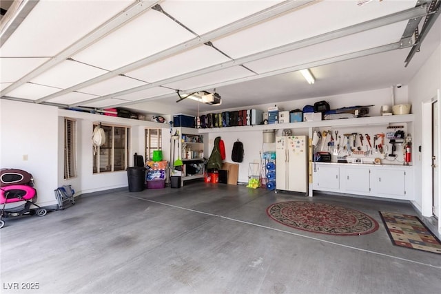 garage featuring a workshop area, a garage door opener, and white refrigerator