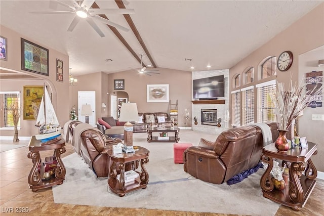 tiled living area with lofted ceiling with beams, a brick fireplace, baseboards, and ceiling fan with notable chandelier