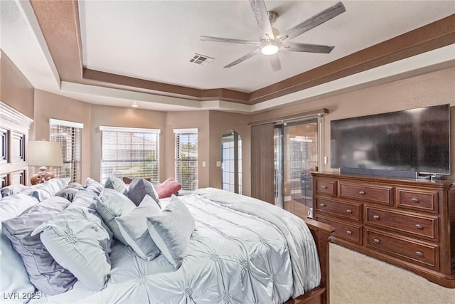 bedroom featuring carpet flooring, access to exterior, a tray ceiling, and ceiling fan