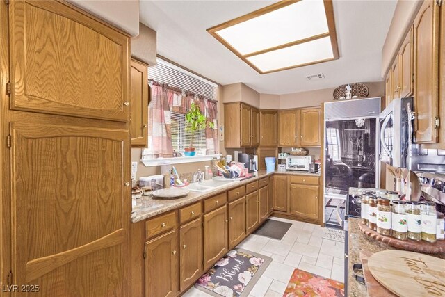 kitchen with brown cabinets, light countertops, and a sink