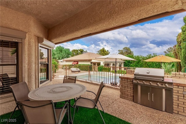 view of patio featuring a fenced in pool and exterior kitchen