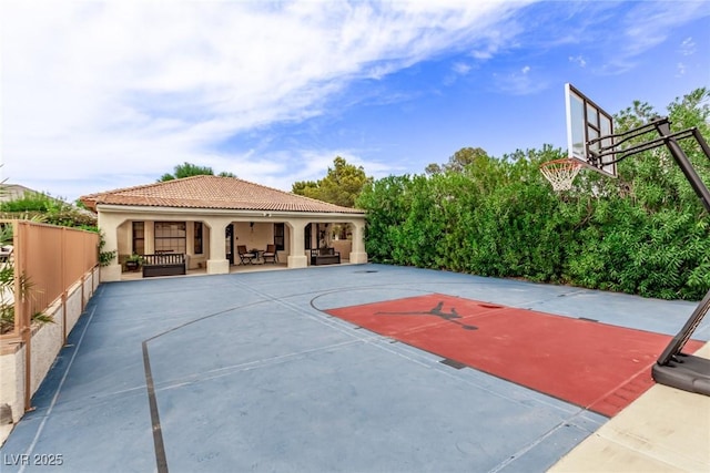 view of sport court with basketball hoop and fence