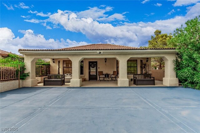 rear view of house featuring fence, a patio, and stucco siding