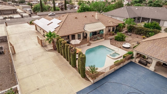 view of swimming pool featuring a patio, a fenced backyard, and a pool with connected hot tub