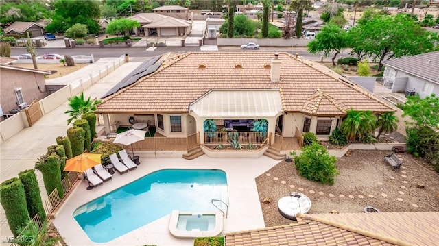 back of house featuring solar panels, a patio, and a fenced in pool