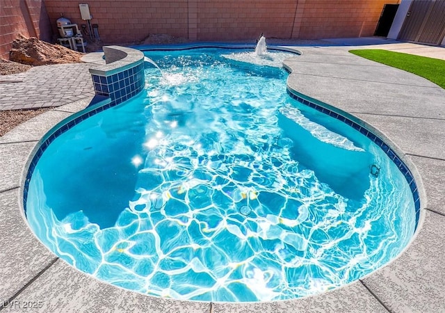 view of swimming pool with pool water feature