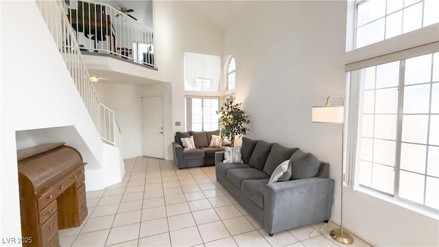 living room with a towering ceiling and light tile patterned floors