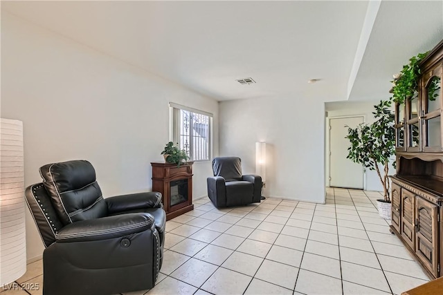 living area featuring light tile patterned floors and a fireplace