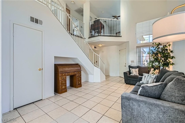 living room featuring light tile patterned flooring and a towering ceiling