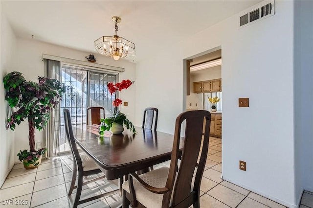 dining area with light tile patterned floors and a notable chandelier