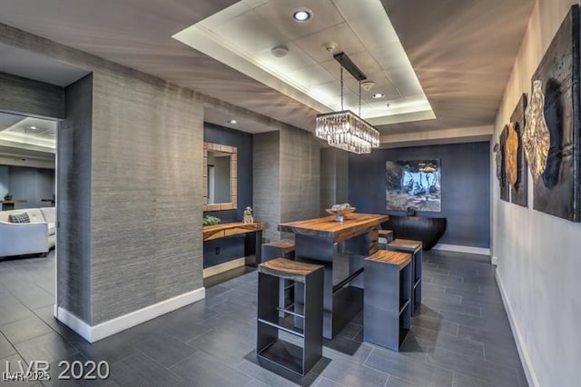 dining room with a notable chandelier and a tray ceiling