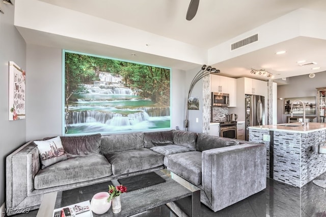 living room with ceiling fan and sink