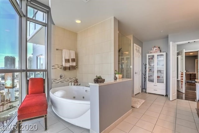 bathroom with independent shower and bath and tile patterned flooring