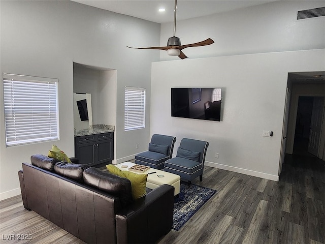 living room featuring ceiling fan, dark hardwood / wood-style flooring, and plenty of natural light