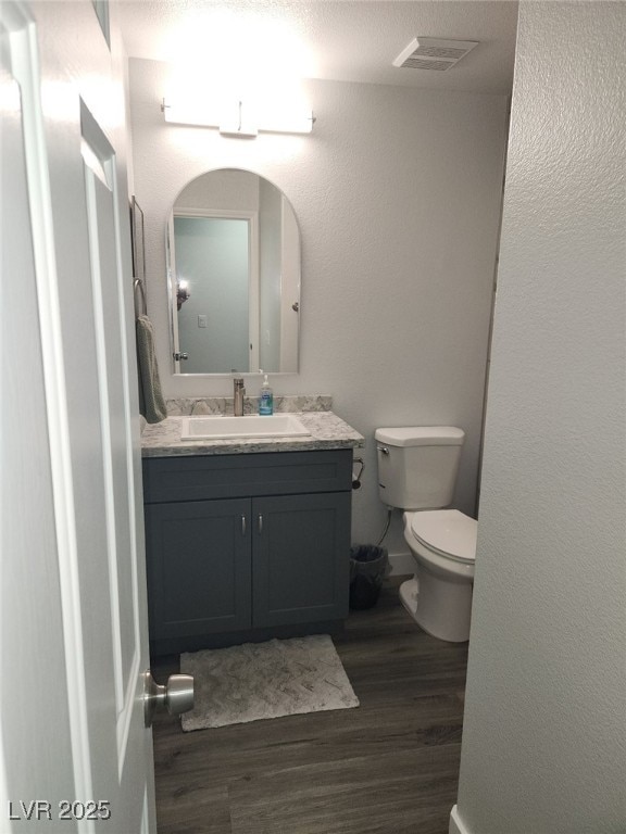 bathroom with hardwood / wood-style floors, vanity, a textured ceiling, and toilet