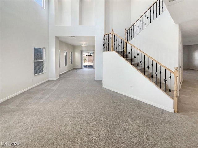 interior space featuring a towering ceiling and carpet floors